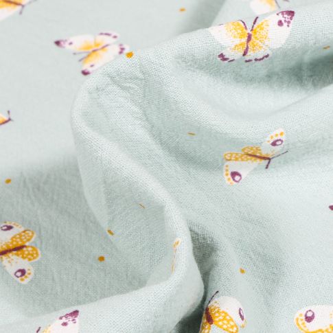 Tissu Coton lavé Papillons colorés sur fond Vert pâle