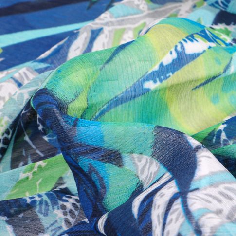 Tissu Mousseline Feuilles tropicales sur fond Bleu roi
