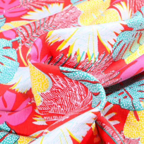 Tissu Jersey Coton Feuilles tropicales multicolores sur fond Rouge