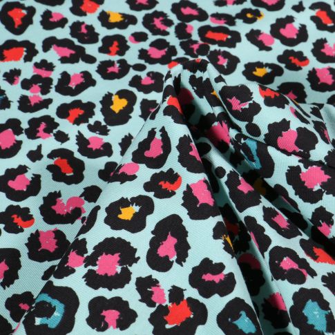 Tissu Jersey Coton Taches léopard multicolores sur fond Bleu lagon