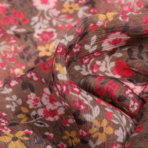 Tissu Mousseline Crépon Fleurs jaunes rouges et blanches sur fond Marron