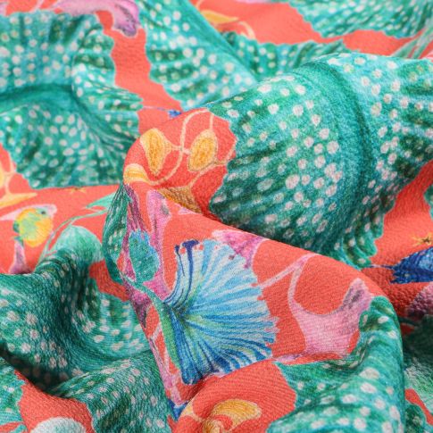 Tissu Crêpe Georgette Grandes feuilles tropicales sur fond Corail