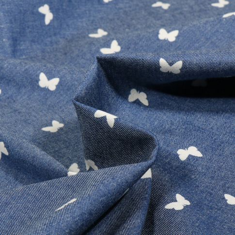 Tissu Chambray  papillons blanc sur fond Bleu denim