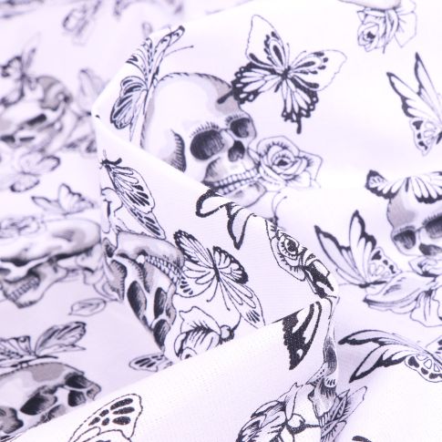 Tissu Coton imprimé Arty Têtes de mort et papillons sur fond Blanc