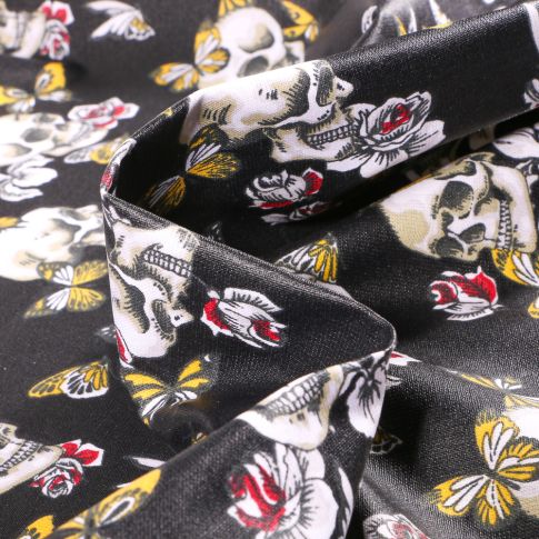 Tissu Coton enduit Têtes de mort et papillons sur fond Noir