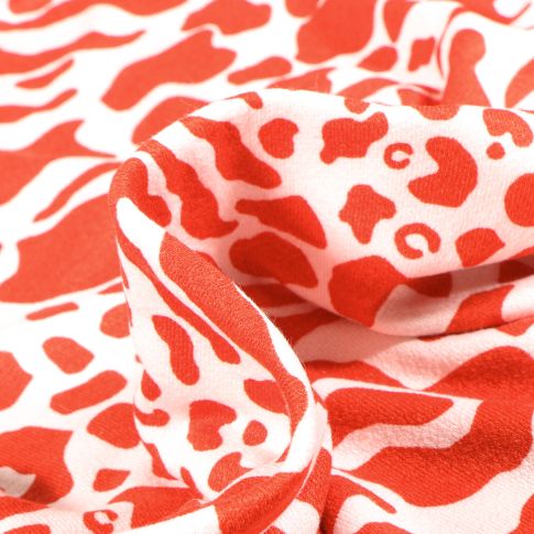 Tissu Jersey Viscose avec aspect crêpe Taches léopard sur fond Rouge