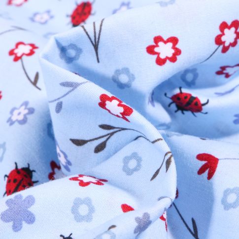 Tissu Coton imprimé Ladybug Coccinelle et fleurs sur fond Bleu ciel