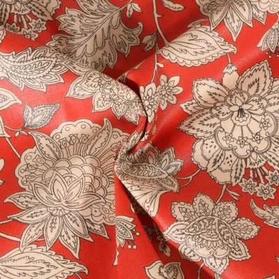 Tissu Coton enduit Sharma fleuris sur fond Rouge - Par 10 cm