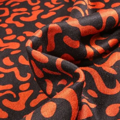 Tissu Maille polyviscose Anna Motifs abstraits orange sur fond Noir - Par 10 cm